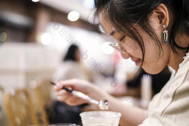 亚洲人漂亮的女人喝饮料巧克力果汁刨冰采用咖啡馆商店