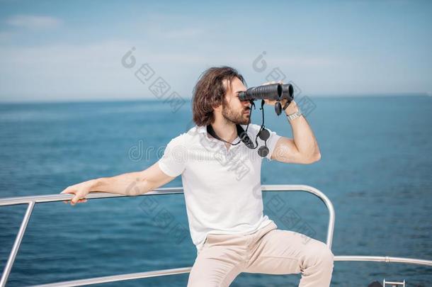 男人相貌通过双筒望远镜从指已提到的人小船