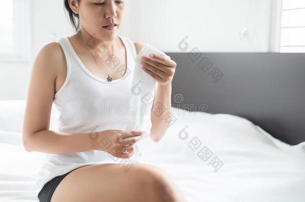 女人使用薄纸纸和寒冷的吹风和流鼻涕的鼻子向床