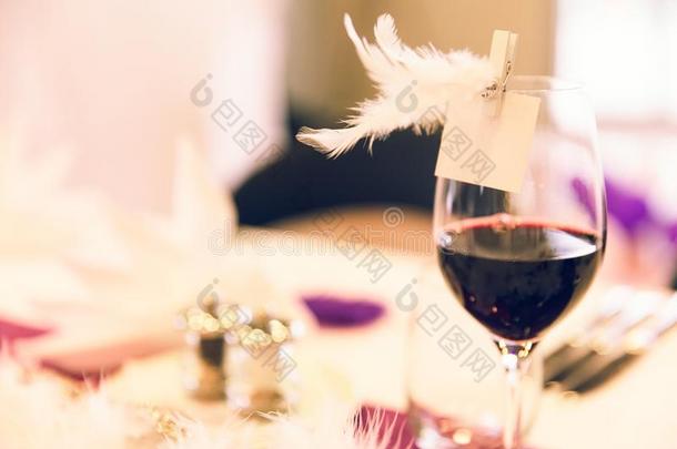 红色的葡萄酒玻璃羽毛名字加标签于向婚礼表