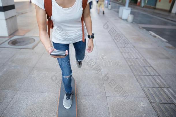 滑板运动员使用智能手机在期间骑马滑板