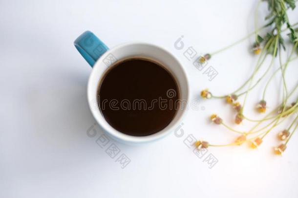 指已提到的人蓝色陶器的咖啡豆杯子和黑的咖啡豆放向白色的书桌