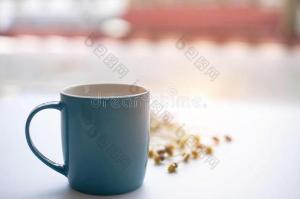 指已提到的人蓝色陶器的咖啡豆杯子,向白色的书桌,