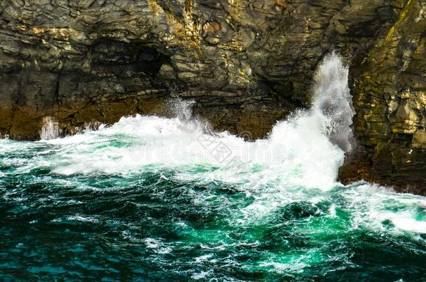 打雷蓝色-绿色的海浪猛撞反对指已提到的人崎岖的悬崖关于