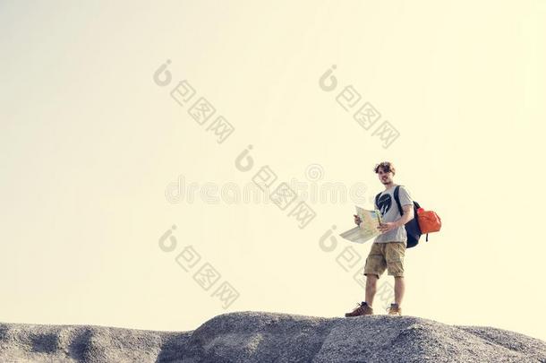 年幼的高加索人男人有样子的地图向一小山