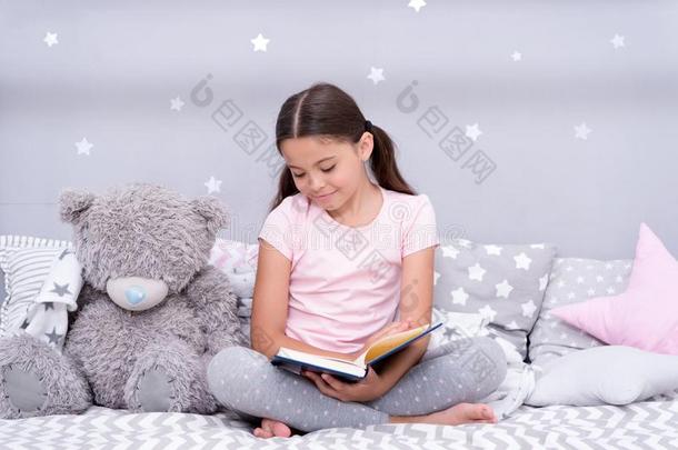 阅读在之前睡.女孩小孩坐床和妇女连衫衬裤熊阅读书.