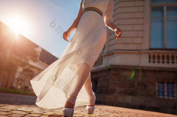 美丽的女人使人疲乏的白色的婚礼衣服在户外采用夏.