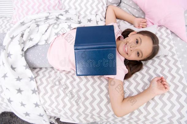 阅读观念.幸福的小孩阅读采用床.小的女孩享有英语字母表的第18个字母