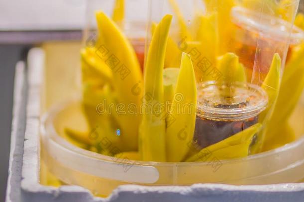 黄色的刨<strong>切</strong>的芒果采用<strong>塑料</strong>制品袋和甜的调味汁为卖在
