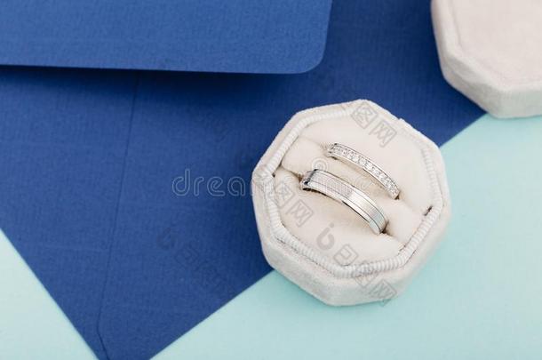 两个银婚礼戒指和菱形向蓝色背景