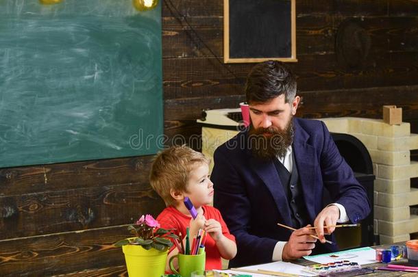教师和胡须,父亲教小的儿子向绘画采用班级