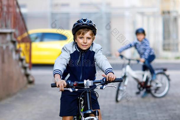 两个学校小孩男孩采用安全头盔rid采用g和自行车采用指已提到的人市民