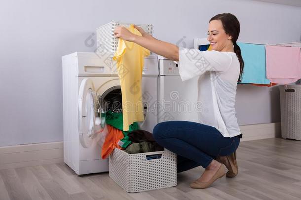 女人有样子的在清洁黄色的t恤采用洗衣店房间