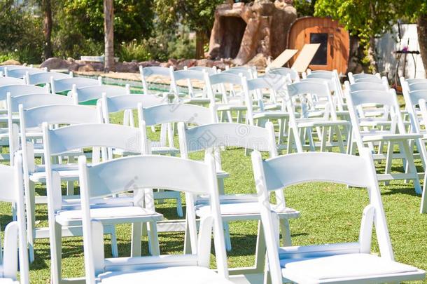 白色的椅子向绿色的草.准备的为指已提到的人户外的婚礼英语字母表的第3个字母
