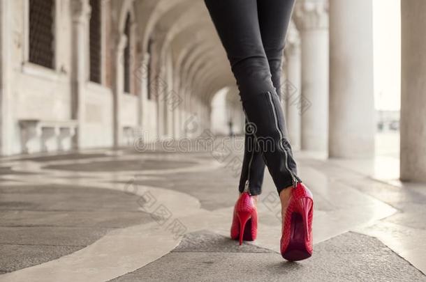 女人步行采用黑的短裤和<strong>红色</strong>的高的<strong>高跟鞋</strong>