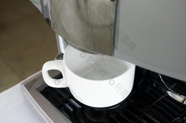 白色的杯子在下面咖啡豆机器