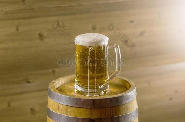 啤酒玻璃流动的起泡沫向木制的桶啤酒节