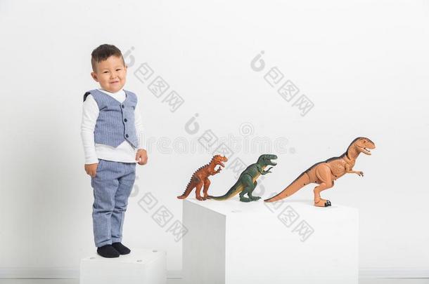男孩和玩具恐龙向白色的背景,婴儿亚洲人