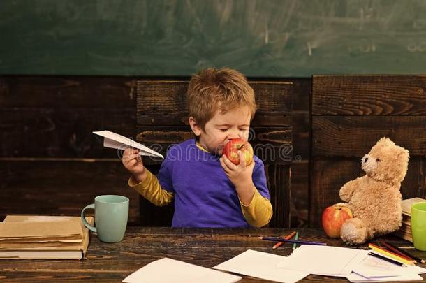 小孩吃苹果和愉快.漂亮的男孩尖锐刺人的成果和他的英语字母表的第5个字母