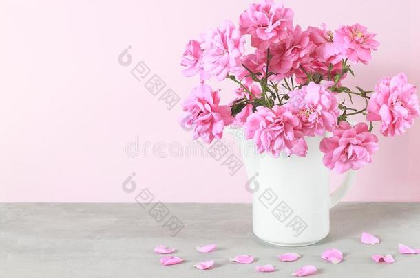 美丽的粉红色的玫瑰花花束采用白色的装饰瓶向灰色表