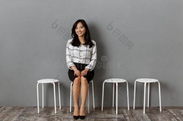 微笑的亚洲人女商人一次向椅子在期间等候