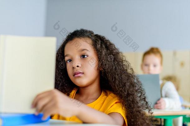 聚焦的小的女学生阅读书