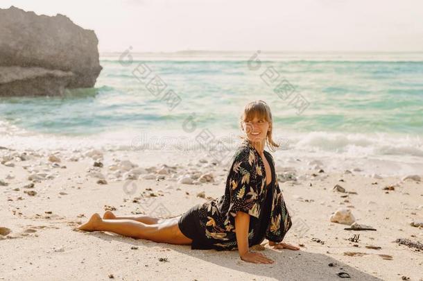 年幼的有魅力的女人做<strong>瑜伽</strong>在海滩和<strong>日</strong>落或孙里斯