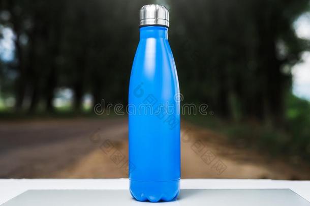 不锈的热水瓶水瓶子向白色的表,户外的.蓝色关口