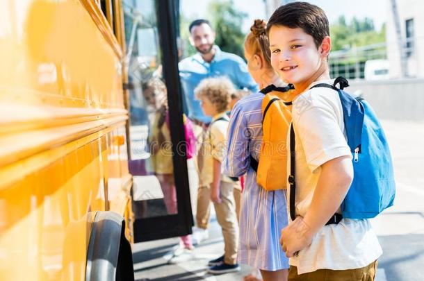 小的男生进入学校公共汽车和同学在期间教
