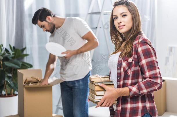 年幼的男人取出货物活动的盒在期间他的女朋友