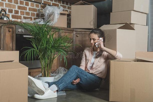 微笑的年幼的女人讲话在旁边智能手机在期间一次在之间