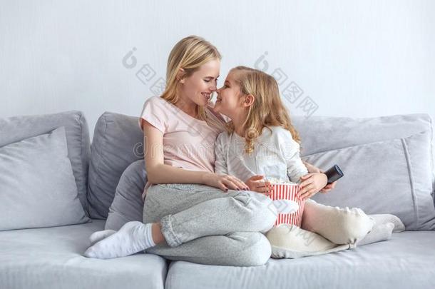 母亲和女儿拥抱在期间一次向长沙发椅
