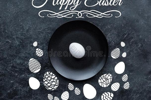 白色的鸡蛋向黑的盘子和幸福的复活节字体和疲惫的