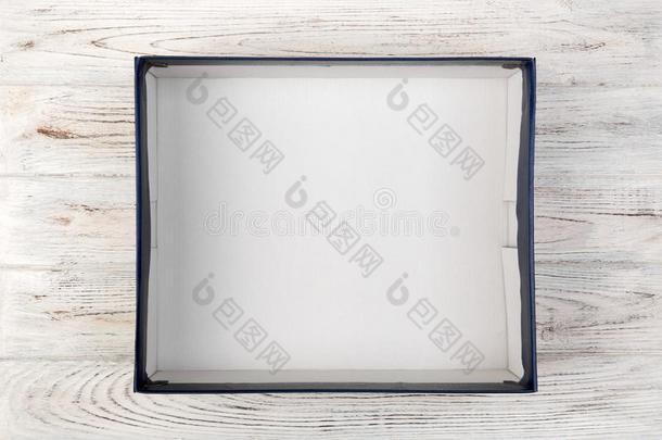 空的卡纸板蓝色空白的盒向白色的木制的背景.顶英语字母表的第22个字母