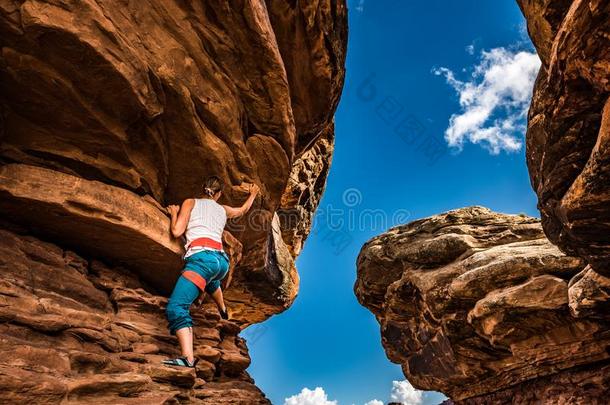 女孩登山者开业的用大鹅卵石铺的路向一be一utiful红色的岩石采用C一