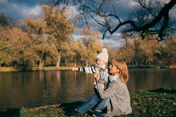 母亲和儿子一次在近处湖采用秋公园向日落和int.看