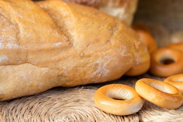 一条面包关于白色的小麦面包,硬面包圈和圆形的小面包或点心.关在上面.家面包师