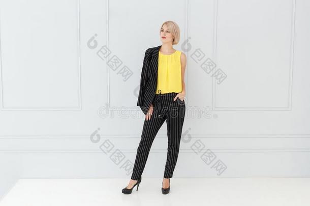 时尚肖像关于女人采用黄色的和黑的一套外衣