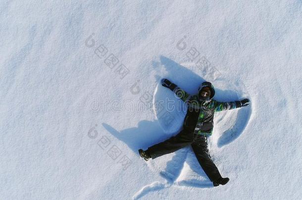 男孩关于7年使雪天使采用雪地区.空气的photograp照片.