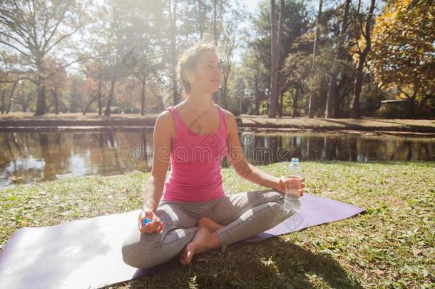 女人轻松后的瑜伽练习采用公园