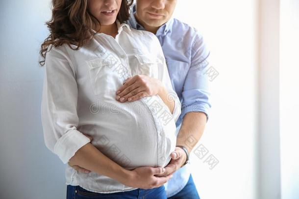 怀孕的女人和她丈夫向白色的背景