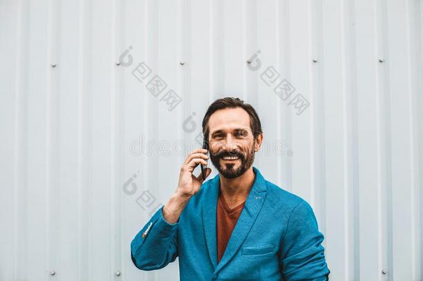 肖像关于有胡须的男人微笑的和所有可爱的电话说话
