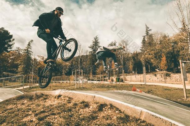 年幼的滑板运动员和bicyclemotorcross双轮摩托车越野赛自行车.年幼的人开业的都市的