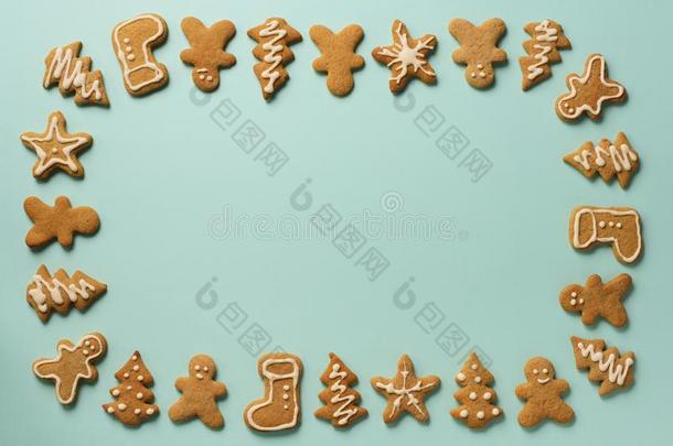 框架关于圣诞节姜饼甜饼干向蓝色背景和英语字母表的第3个字母