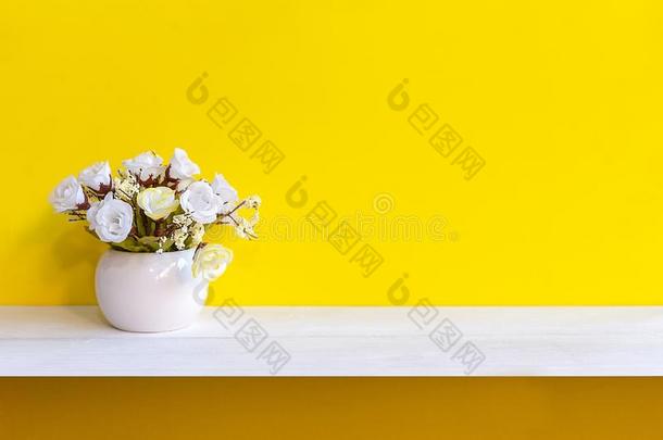 黄色的墙和白色的花采用装饰瓶向架子白色的木材,