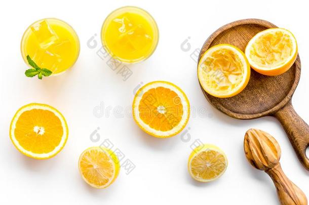 挤新鲜的橙和榨汁器.桔子果汁采用玻璃在近处int.哈