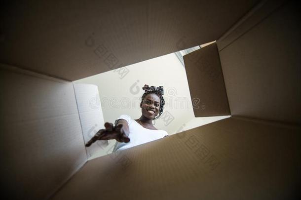 微笑的年幼的非洲的女人<strong>开幕</strong>一c一rton盒,reloc一tion一nd