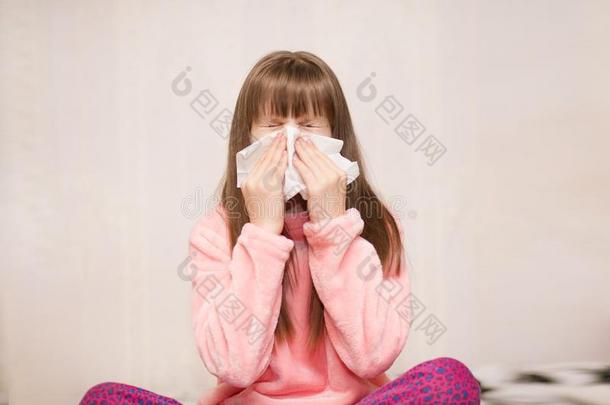 小的女孩和流鼻涕的鼻子抹布她鼻子
