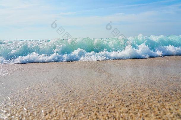 波和起泡沫打沙向指已提到的人热带的海滩.