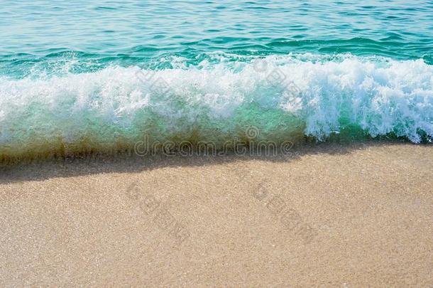 波和起泡沫打沙向指已提到的人热带的海滩.